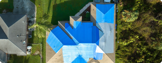 Aerial view of residential home with bright blue swimming pool and surrounding patio
